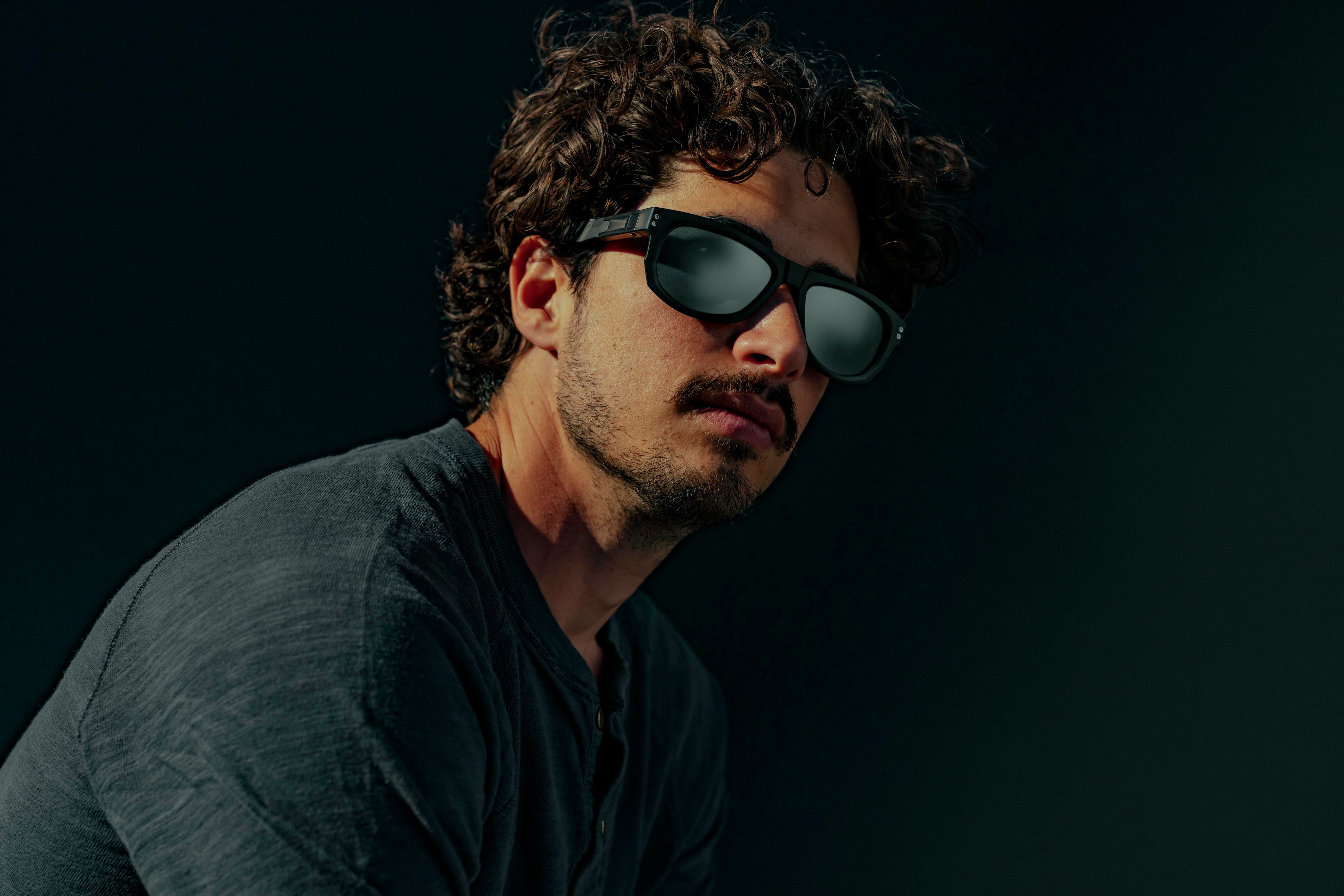 Man wearing sunglasses with a dark background