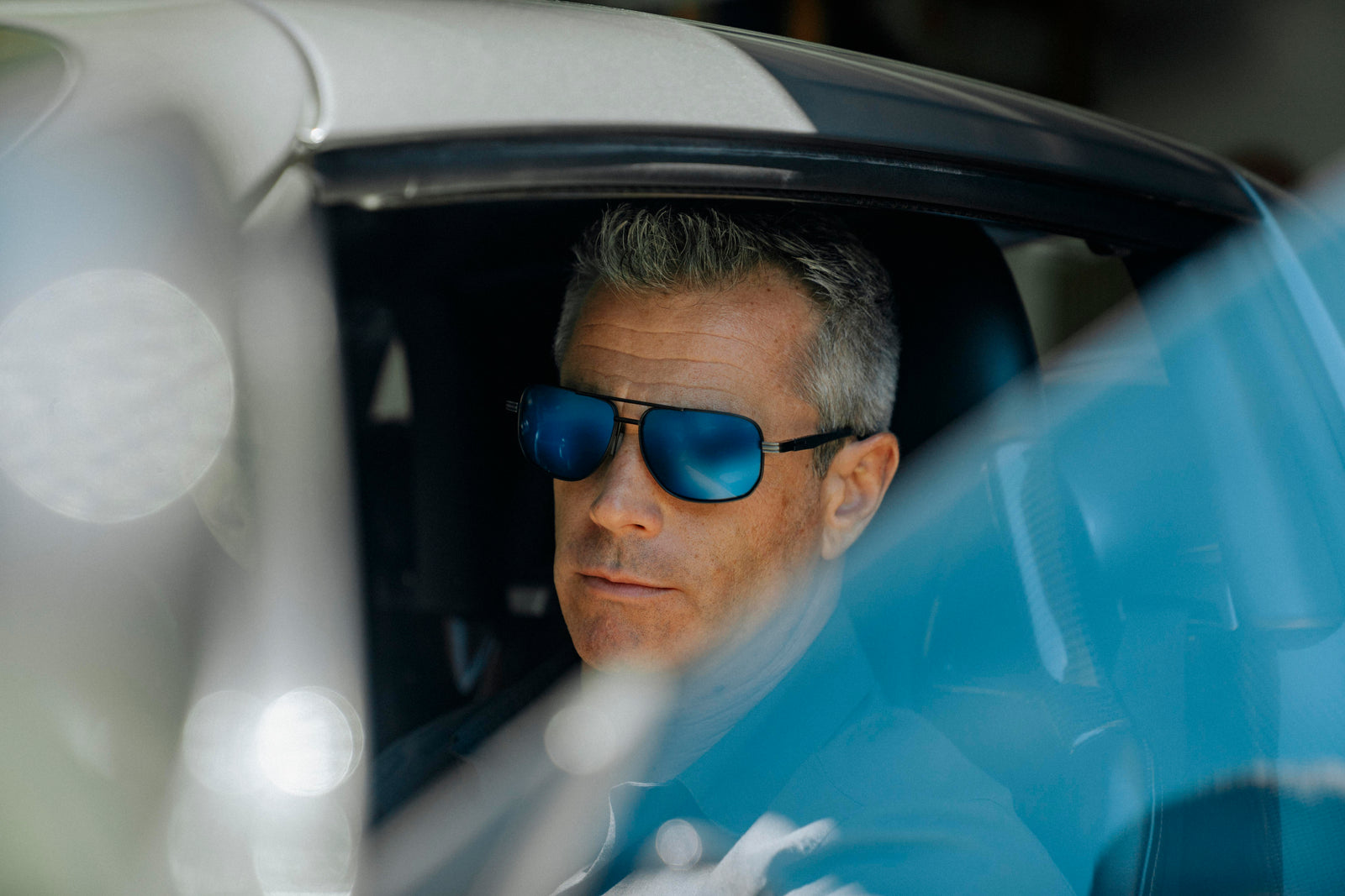 Man wearing sunglasses sitting inside a car